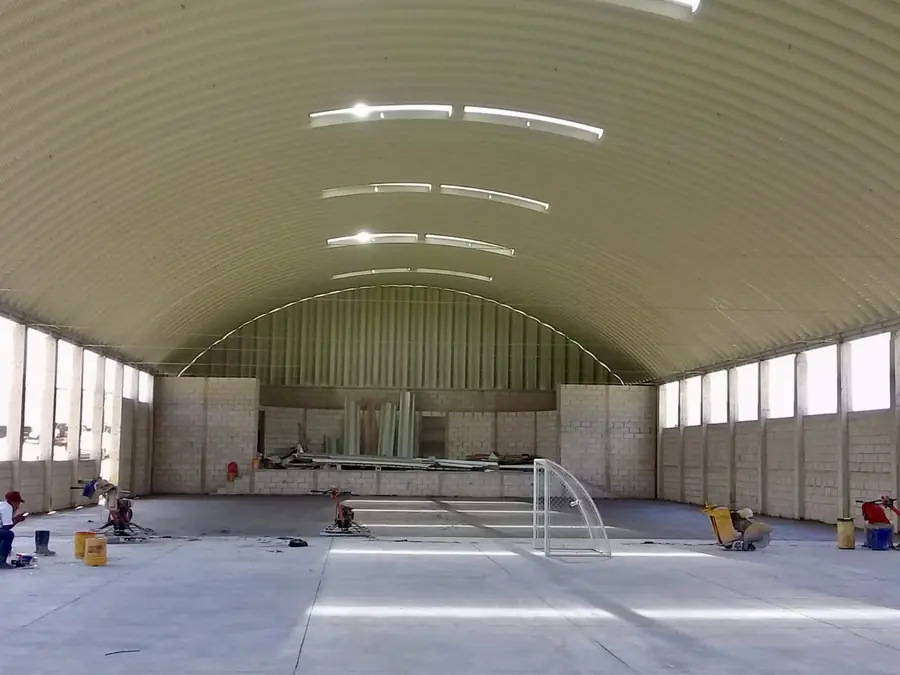 Gimnasio bajo techo curvo con tragaluces
